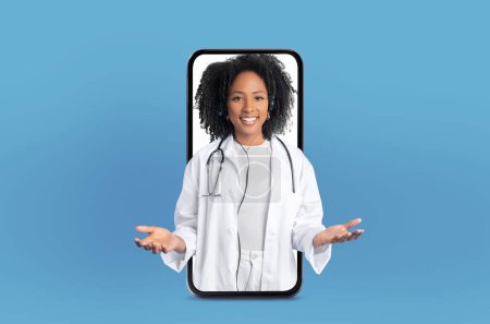 A telemedicine session is featured with a young African American woman medical expert, who stands inside a smartphone screen in a well-equipped medical office.