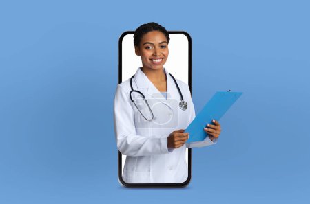 A young black lady doctor stands inside a smartphone screen, engaging in a virtual telemedicine consultation in a bright, modern clinic.