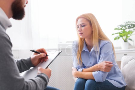 Foto de Psicoterapia. Deprimida mujer milenaria compartiendo sus problemas con el psicólogo en sesión personal, espacio vacío - Imagen libre de derechos