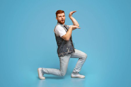 Lustiger Millennial-Typ, der im ägyptischen Stil auf blauem Hintergrund tanzt, Studio, Kopierraum