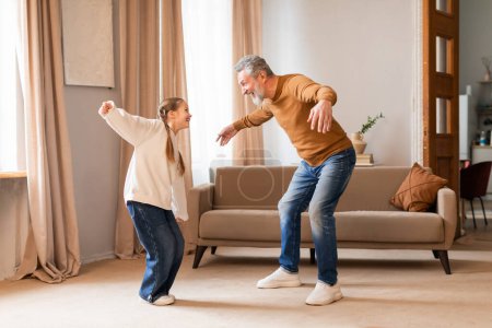 Ein fröhlicher Großvater führt mit seiner kleinen Enkelin einen verspielten Tanz in der Wärme ihres Wohnzimmers auf, unterstrichen durch das weiche Tageslicht, das durch die Vorhänge einströmt.