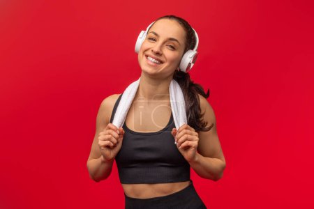 A woman is depicted wearing a sports bra while listening to music through headphones. She appears to be engaged in physical activity or exercise, exemplified by her attire.