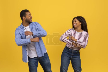 Photo for A young African American man and woman share a joyous moment, playfully moving with their hands and laughing heartily. - Royalty Free Image