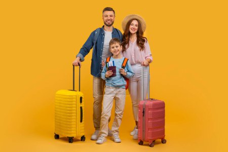 Ein Mann, eine Frau und ein Kind stehen zusammen neben einem knallgelben und roten Koffer. Sie scheinen sich auf eine Reise oder Reise vorzubereiten, gelber Hintergrund