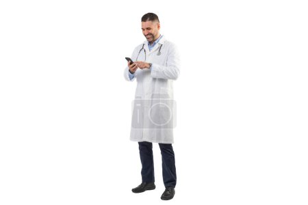 Un médico hombre vestido con una bata blanca de laboratorio, con un estetoscopio alrededor de su cuello, comprueba los mensajes en su teléfono inteligente durante las horas de luz del día en su turno en el hospital.