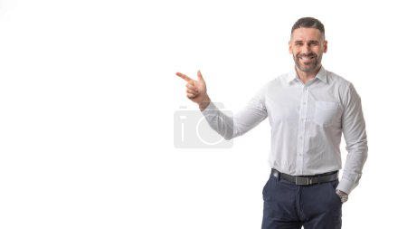 A smiling man dressed in business attire points confidently with his index finger against a clean, white background. The man exudes a professional yet approachable demeanor, copy space