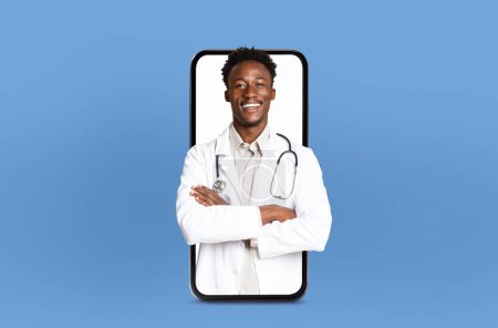 Un médico negro está mirando atentamente la pantalla de su teléfono con un estetoscopio adjunto, posiblemente comprobando la información médica o comunicándose con sus colegas..
