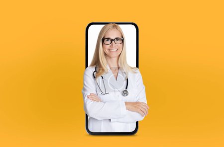 A smiling woman doctor with glasses and a stethoscope around her neck stands confidently, appearing to emerge from a smartphone screen set against a vibrant yellow background