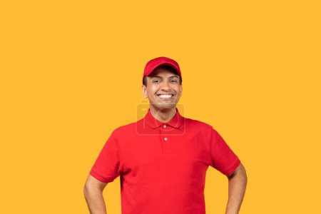 A cheerful man stands with his hands on his hips, wearing a bright red uniform and matching cap, against a vibrant yellow backdrop. He is smiling widely, appearing enthusiastic and approachable.