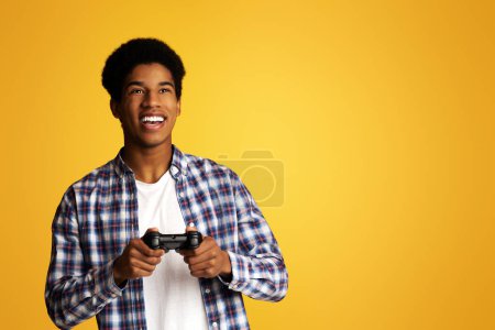 Glücksspielsucht. Aufgeregter Typ mit Joystick und Videospielen, gelber Hintergrund