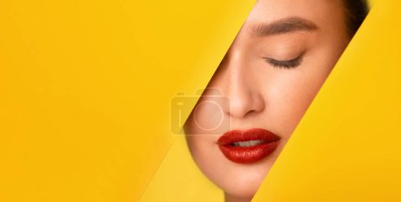 Un primer plano de una cara de mujer con un vibrante lápiz labial rojo que sobresale sobre un fondo amarillo brillante. El foco está en la negrita sombra de lápiz labial en contraste con el colorido telón de fondo.