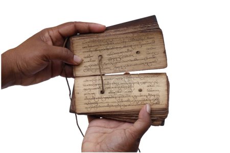 Téléchargez les photos : La posture de tenir un manuscrit de feuille de palmier antique dans les deux mains et tenant le livre ouvert et révélant le contenu à l'intérieur. Ce manuscrit de feuille de palmier du Sri Lanka, sur un fond isolé - en image libre de droit