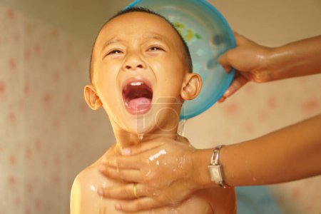Foto de Niño llorando por el agua fría de la ducha - Imagen libre de derechos