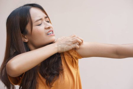 Foto de Asian woman having an itchy shoulder - Imagen libre de derechos