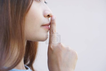 Téléchargez les photos : Asiatique femme couvre sa bouche avec son doigt - en image libre de droit