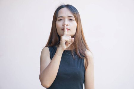 Téléchargez les photos : Asiatique femme couvre sa bouche avec son doigt - en image libre de droit