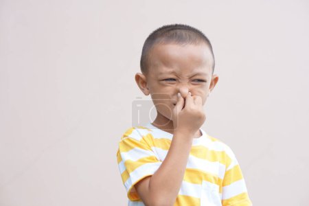 Foto de Un chico cubriéndose la nariz con las manos de un mal olor - Imagen libre de derechos