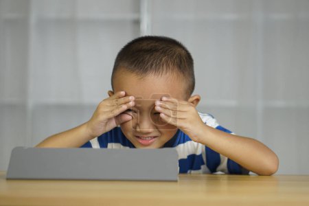 Foto de Boy tiene tensión ocular de mirar a la computadora durante mucho tiempo - Imagen libre de derechos