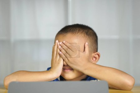 Photo for Boy has eye strain from looking at computer for a long time - Royalty Free Image