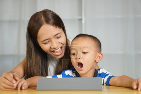 Téléchargez les photos : Heureux mère et fils de regarder des films ensemble sur un ordinateur portable - en image libre de droit