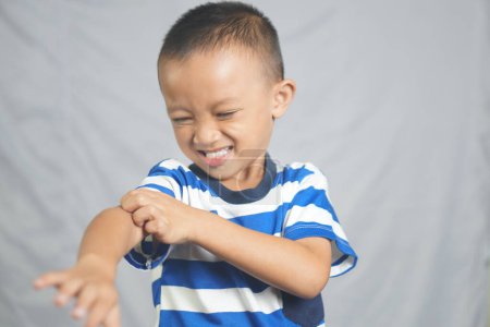 Photo for The boy has an itchy area on his arm. - Royalty Free Image