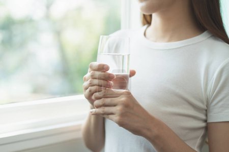 Foto de Clean freshwater concept. Woman drink mineral water in the morning for good health. - Imagen libre de derechos