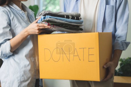 Téléchargez les photos : Personnes préparant des vêtements dans la boîte de don se préparant à donner à un autre peuple - en image libre de droit