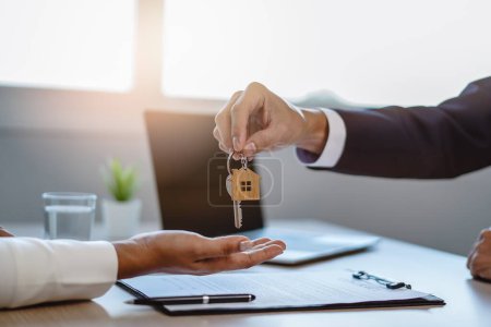 Téléchargez les photos : Close up view hand of property realtor / landlord giving key house to buyer / tenant. - en image libre de droit
