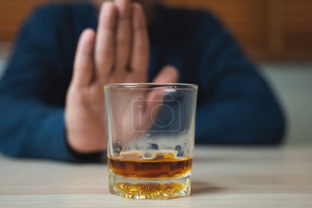 Téléchargez les photos : Drunk men deny drinking more glass of whisky by pushing away. - en image libre de droit