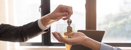 Téléchargez les photos : Close up view hand of property realtor landlord giving key house to buyer tenant. - en image libre de droit