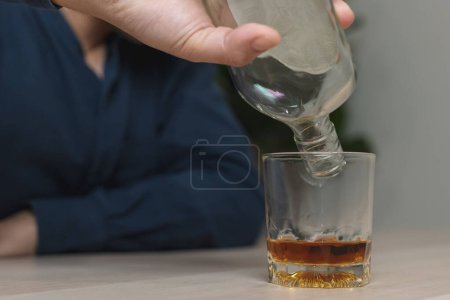 Foto de Drunk man holding whiskey glass on the table - Imagen libre de derechos