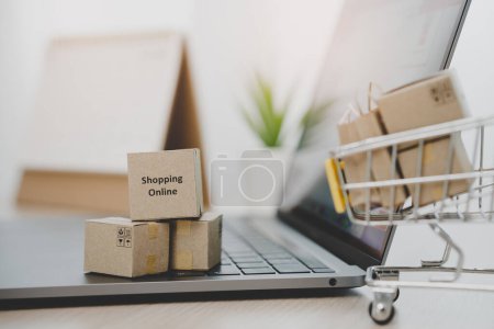 Foto de Internet shopping e commerce concept, Parcel boxes of product on laptop computer related buy from online store. - Imagen libre de derechos