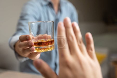 Téléchargez les photos : Person deny alcohol drink from his friend - en image libre de droit