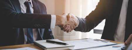 Téléchargez les photos : Main du client et du banquier serrant la main sur la table de réunion après le budget d'investissement des entreprises fait - en image libre de droit