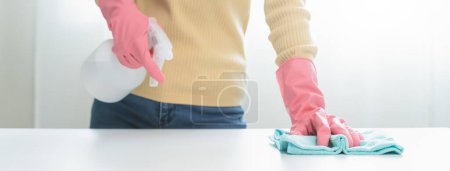 Photo for Happy Female housekeeper service worker wiping table surface by cleaner product to clean dust. - Royalty Free Image