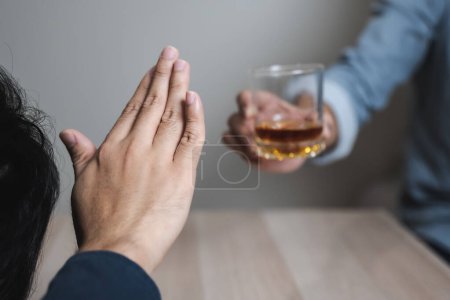 Foto de Drunk men deny drinking more glass of whisky by pushing away. - Imagen libre de derechos