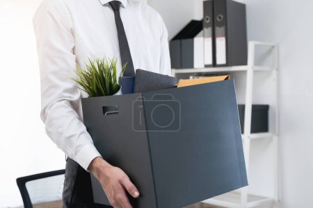 Téléchargez les photos : Licencier des travailleurs. La taille de la bannière ferme les mains d'un homme d'affaires tenant une boîte de choses pour quitter le bureau après avoir été viré du travail. - en image libre de droit