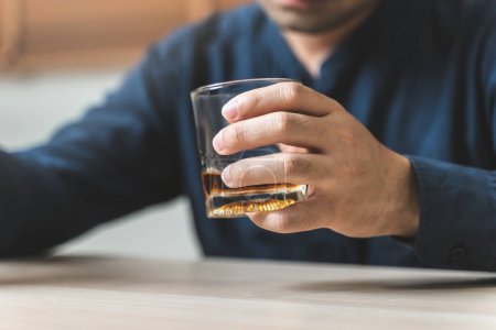 Téléchargez les photos : Close up hand man holding a glass of whisky - en image libre de droit