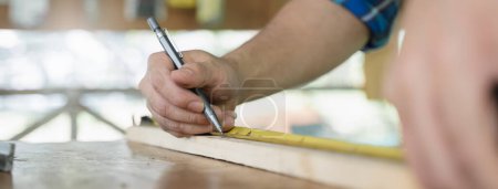Foto de Hands of person doing diy project at home. Man measuring wood to doing cabinet craftworks as a hobby. - Imagen libre de derechos