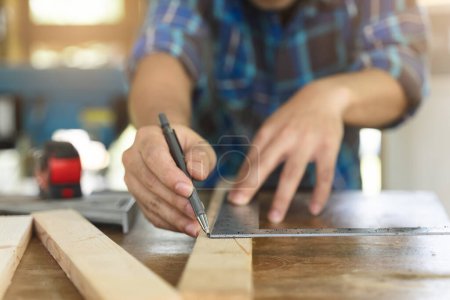 Téléchargez les photos : Hands of person doing diy project at home. Man measuring wood to doing cabinet craftworks as a hobby. - en image libre de droit