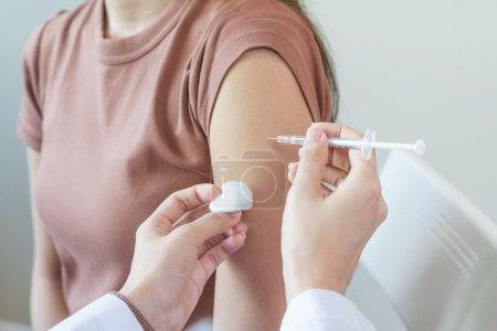 Menschen lassen sich impfen, um eine Pandemie zu verhindern. Frau mit medizinischer Gesichtsmaske erhält eine Dosis des Impfstoffs gegen das Coronavirus von einer Krankenschwester im Krankenhaus des medizinischen Zentrums