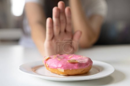 Foto de Las mujeres consideran dejar de comer alimentos dulces tienen mucho azúcar para una buena salud y perder peso - Imagen libre de derechos