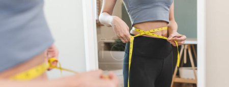 Foto de Joven mujer delgada midiendo su cintura por cinta métrica después de una dieta - Imagen libre de derechos