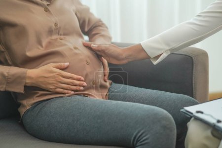 Téléchargez les photos : Doctor checking belly of a pregnant woman - en image libre de droit