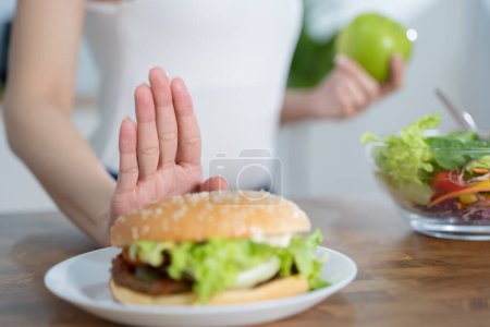 Téléchargez les photos : Women avoid fast food during diet sessions to lose weight and choose healthy food that has vitamins and nutrition. - en image libre de droit