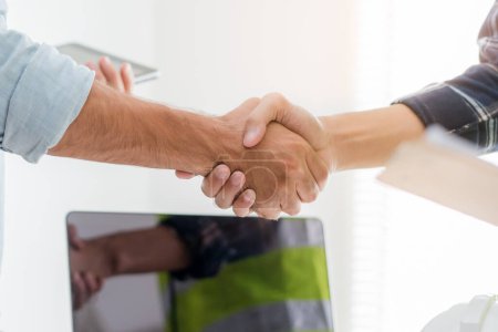 Téléchargez les photos : Construction worker and contractor. Client shaking hands with team builder in renovation site. - en image libre de droit