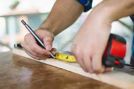Photo for Hands of person doing diy project at home. Man measuring wood to doing cabinet craftworks as a hobby. - Royalty Free Image