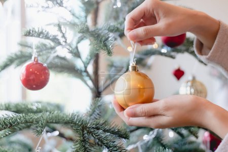 Téléchargez les photos : Close up hands of person decorating Christmas tree - en image libre de droit
