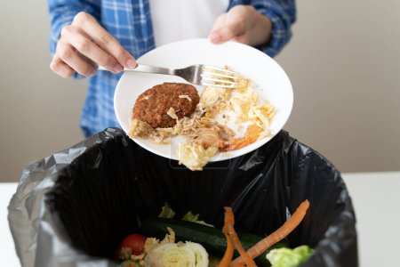 Foto de La gente pone basura biológica de los desperdicios de alimentos en los hogares a los contenedores de compost para hacer fertilizantes para reducir la contaminación ambiental mundial. - Imagen libre de derechos