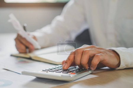 Photo for Close up hands of accountant calculating tax refund using calculator - Royalty Free Image